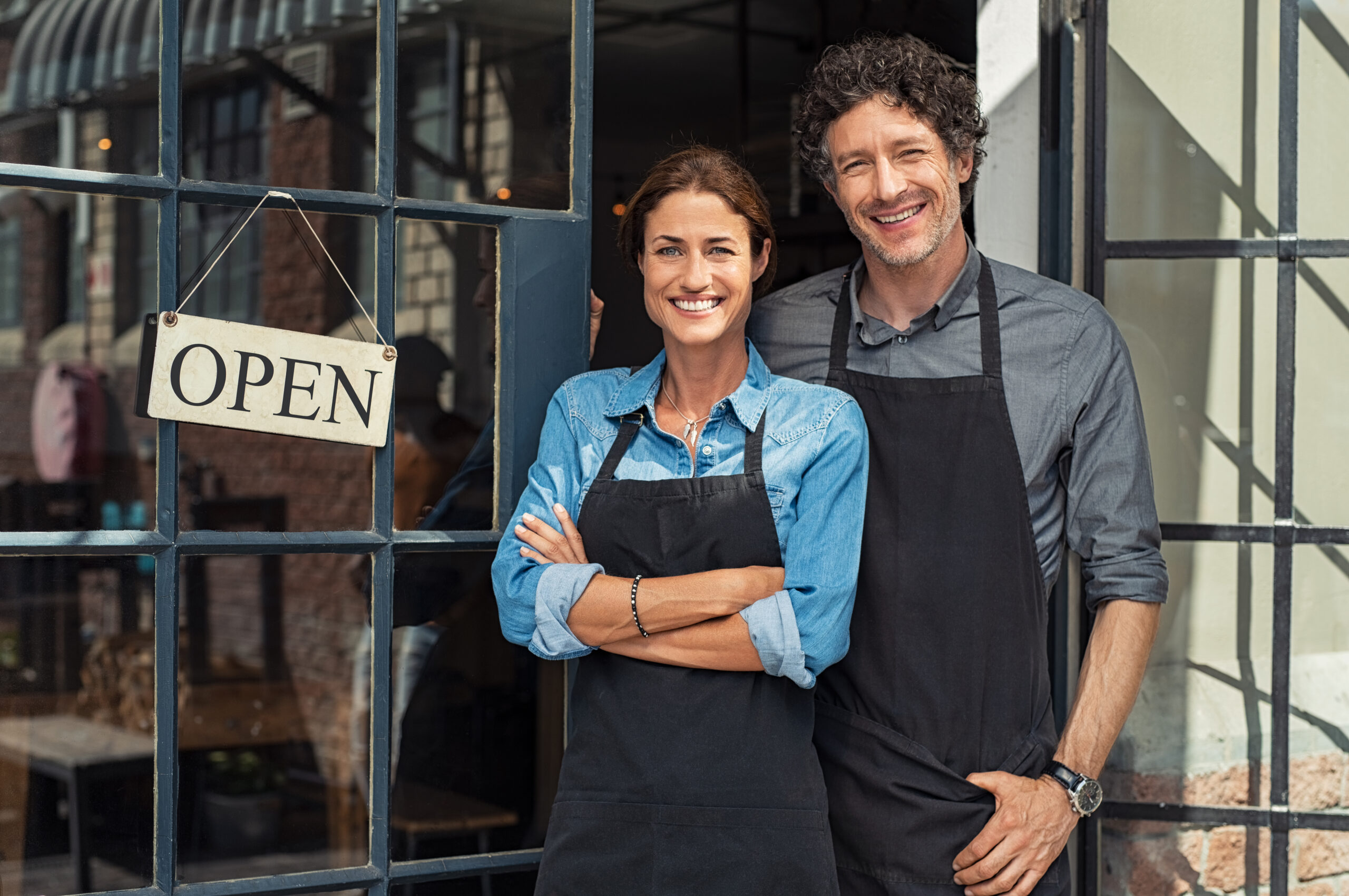 Two,Cheerful,Small,Business,Owners,Smiling,And,Looking,At,Camera Two,Cheerful,Small,Business,Owners,Smiling,And,Looking,At,Camera
